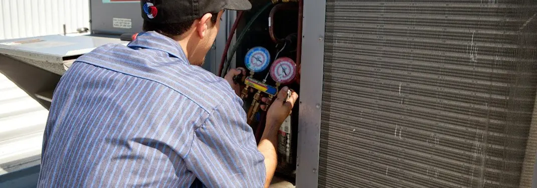 HVAC technician servicing a condenser unit in Burnsville