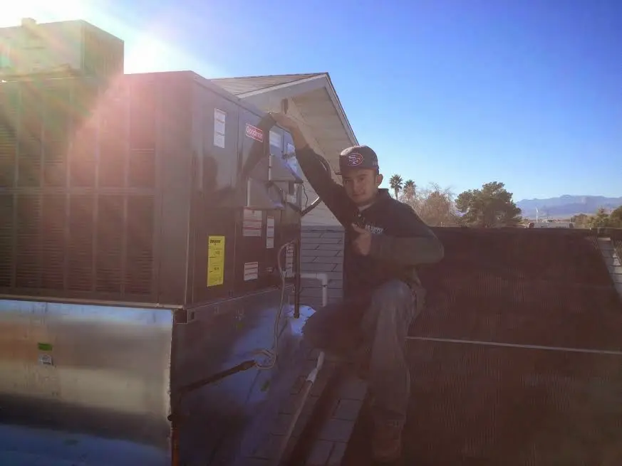 HVAC technician performing Heat Pump Repair on a rooftop unit in Burnsville